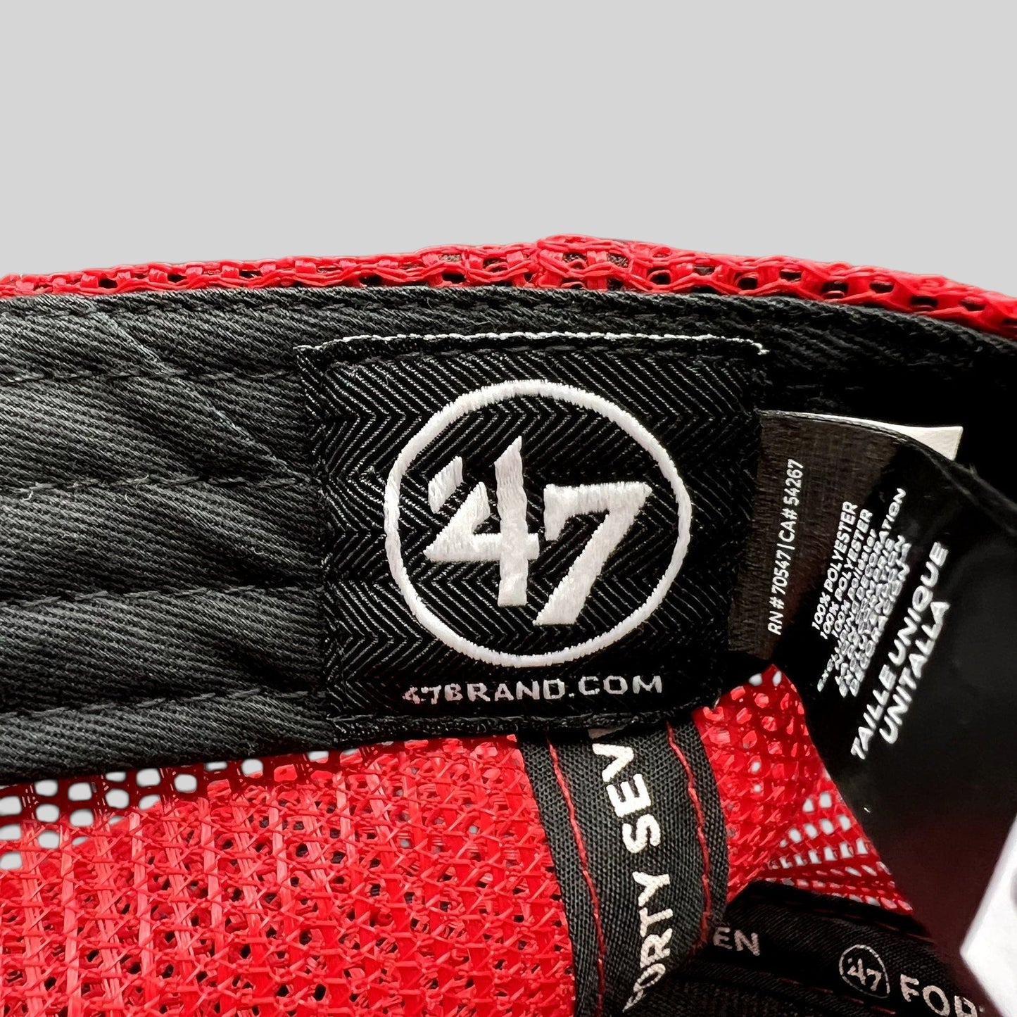Raree Finds ’47 Brand trucker hat interior showing the black woven logo label and red mesh construction
