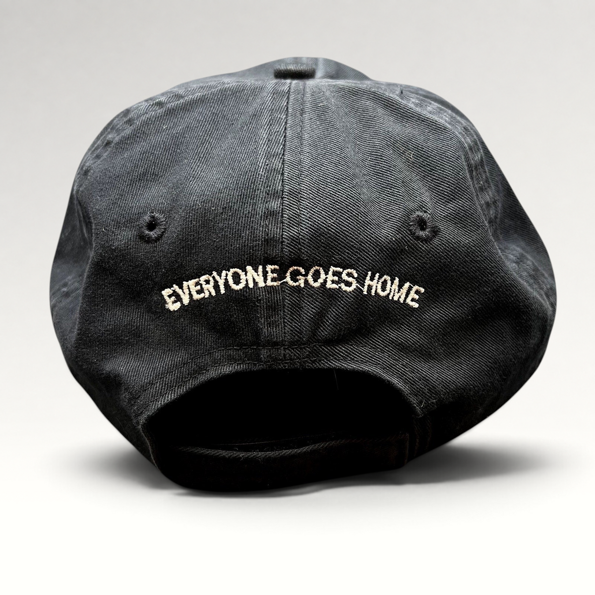 Raree Finds black cotton strapback hat with Everyone Goes Home embroidered on the back in white thread