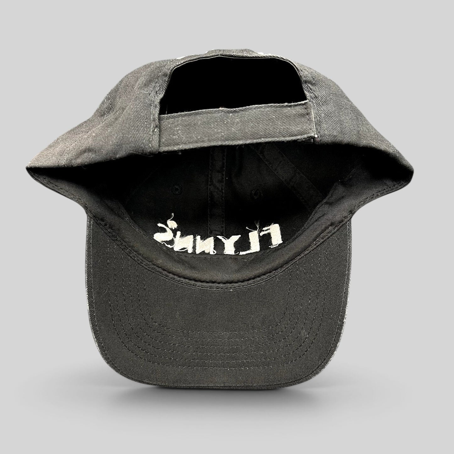 Raree Finds black unstructured strapback hat with white embroidered Flynn’s logo and shamrock detail, back view