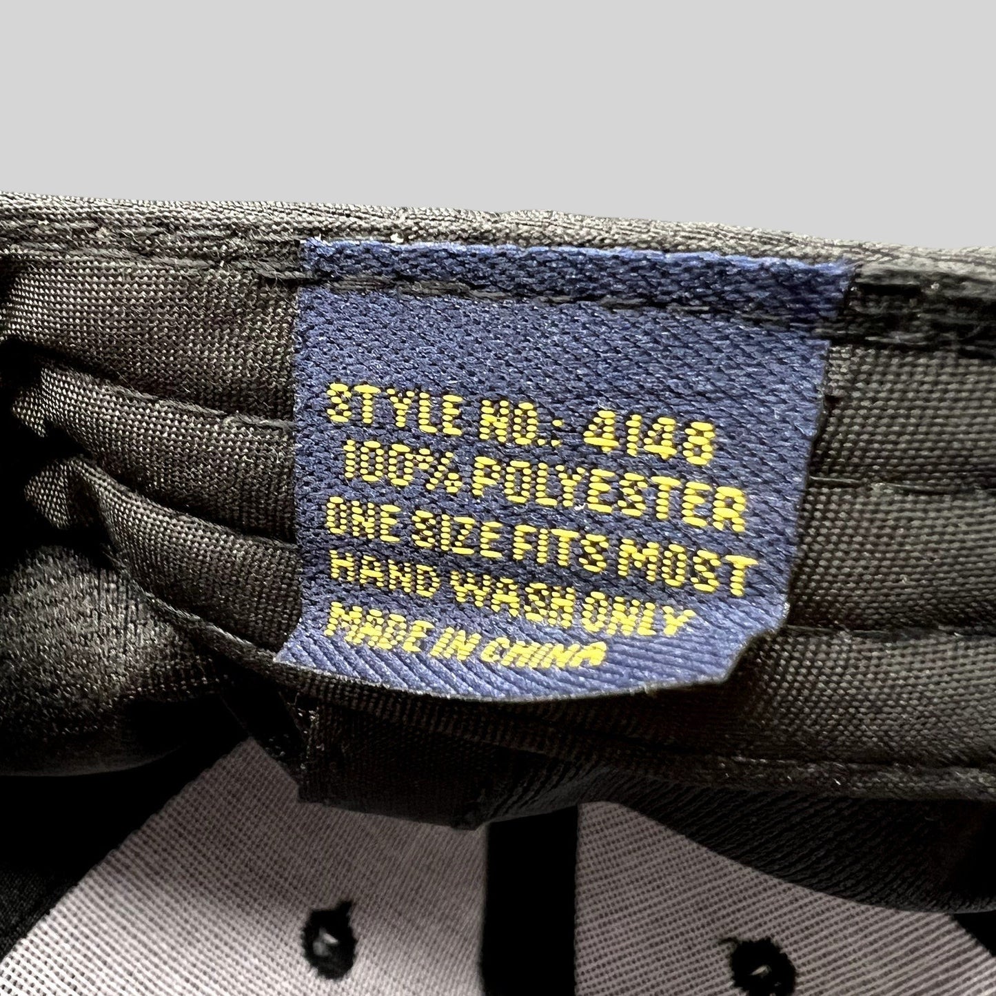 Raree Finds black hat interior tag showing 100 percent polyester material and care instructions