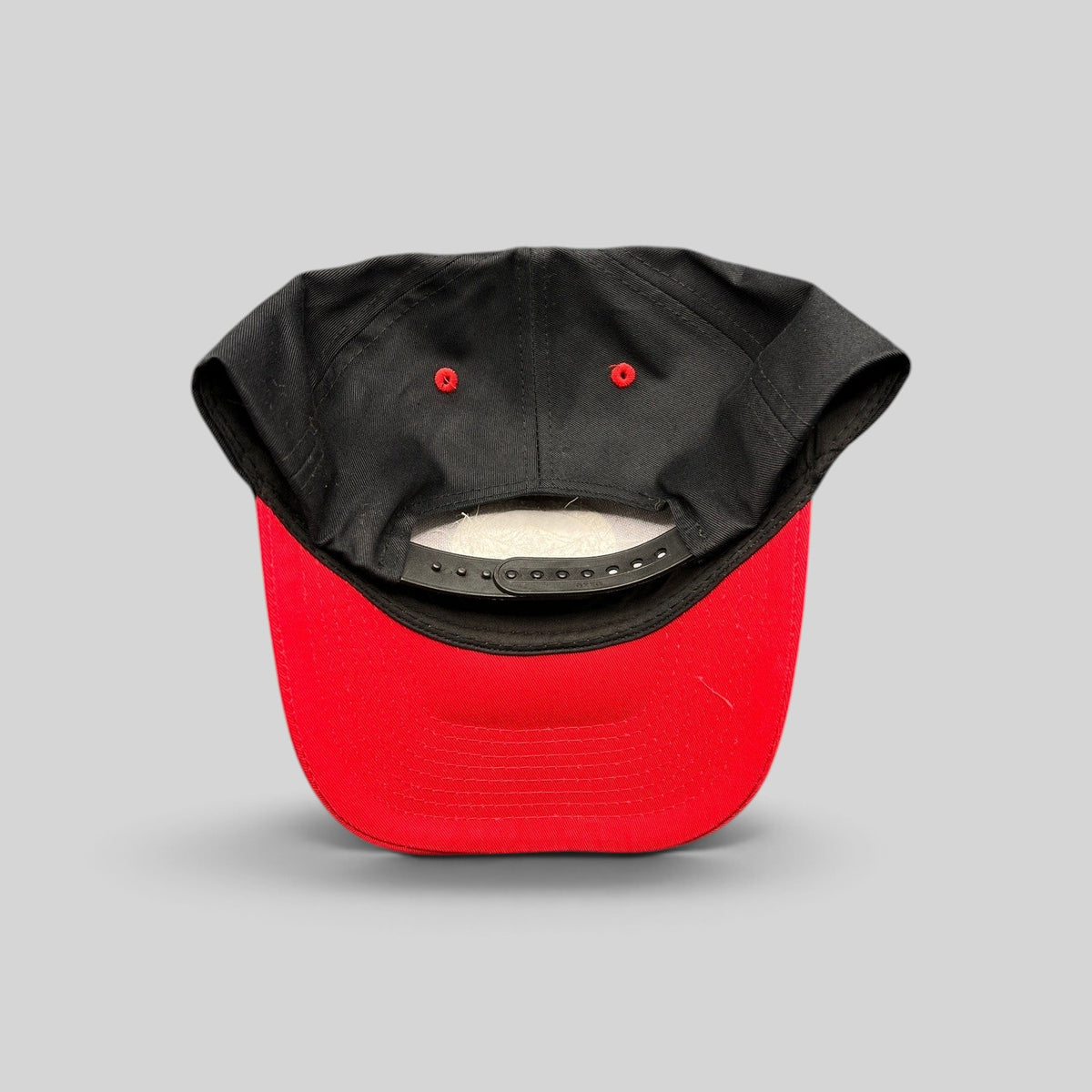 Raree Finds Diamond Head Clothing Co. snapback hat showing the black crown, red brim, and adjustable plastic strap.