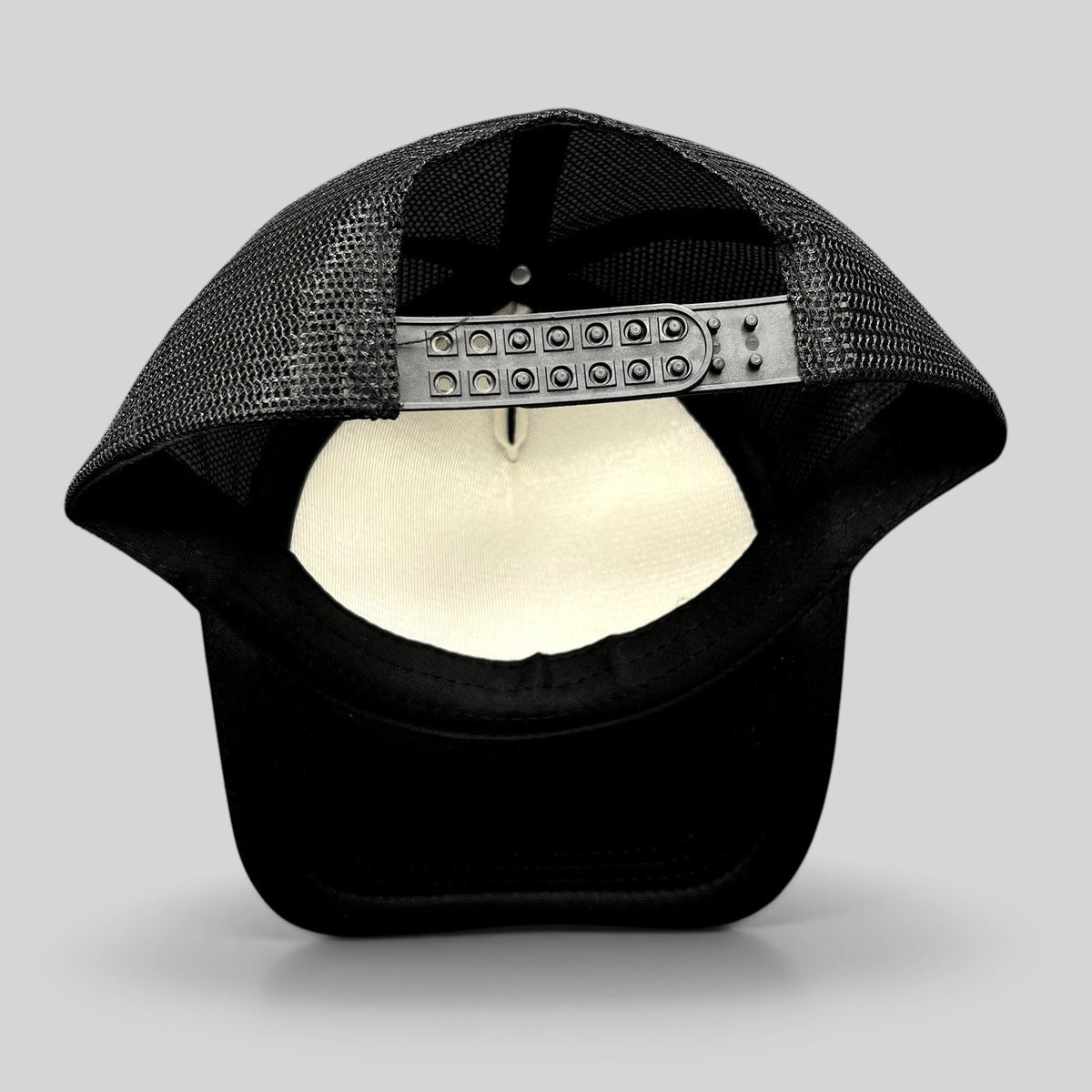 Raree Finds Milo black foam trucker hat showing the adjustable snapback closure and breathable mesh back panels
