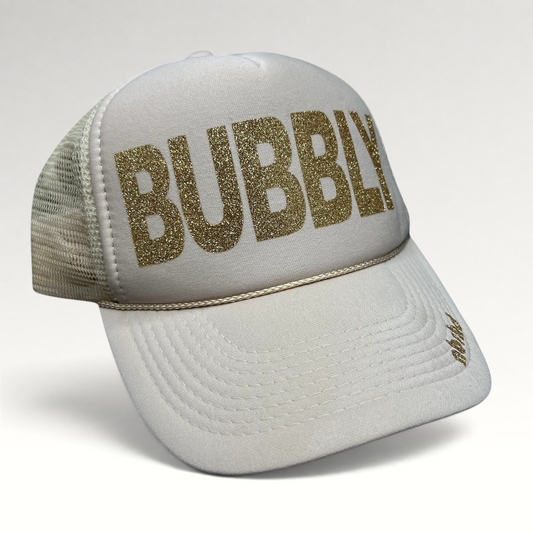 Raree Finds cream trucker hat with gold glitter BUBBLY text and mesh back, featuring NBRHD branding on the visor.
