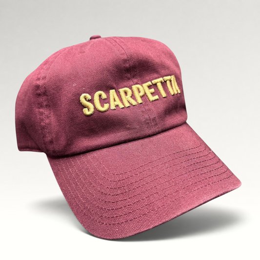 Raree Finds burgundy strapback hat with Scarpetta embroidered in gold on the front, featuring a structured crown.