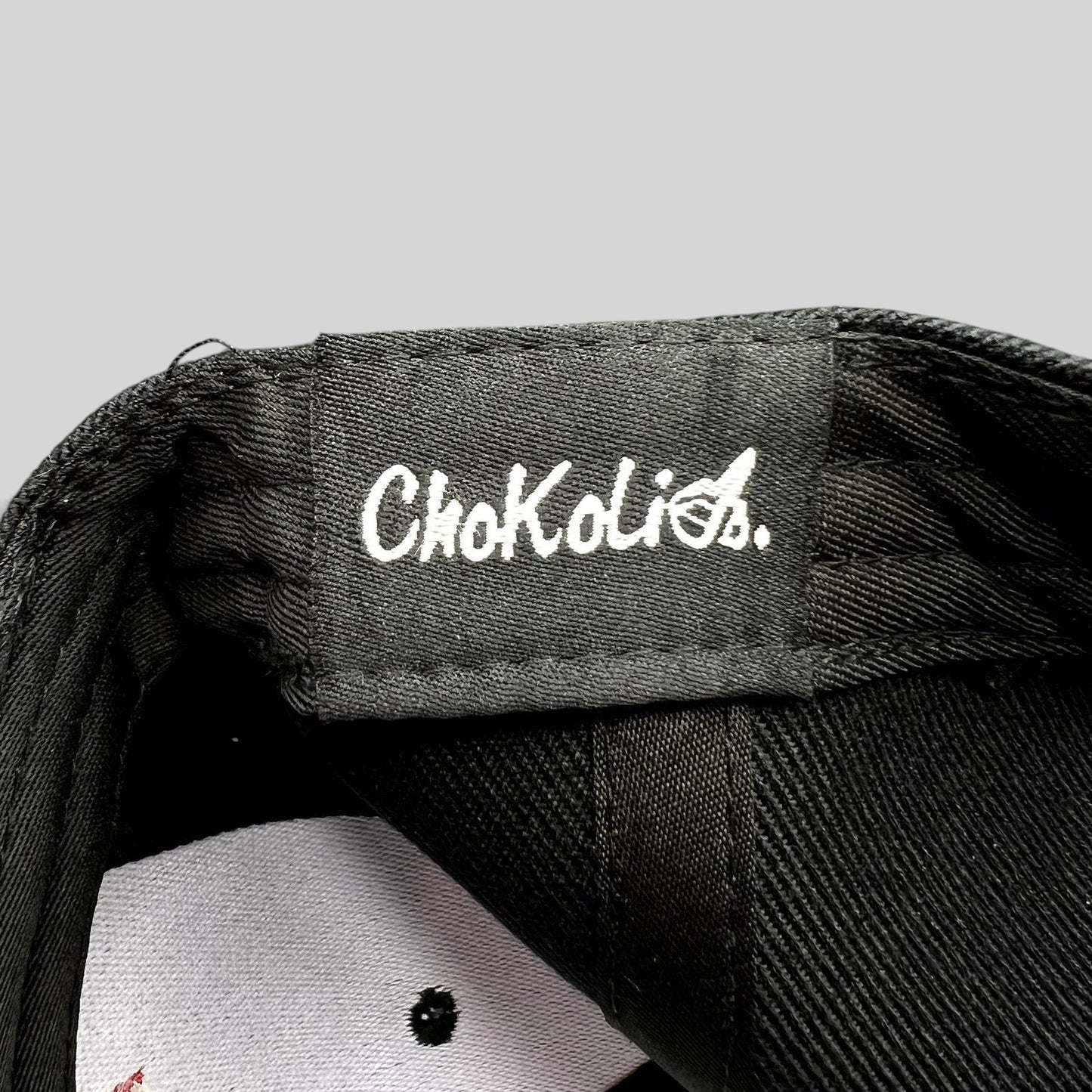 Raree Finds black Chokolids snapback hat interior label detail showing white embroidered brand logo