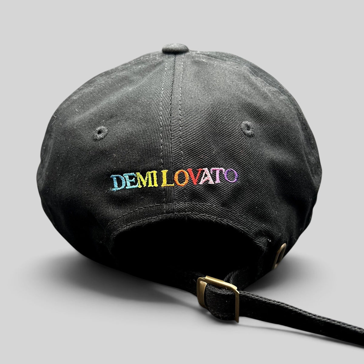 Raree Finds black cotton dad hat with colorful rainbow DEMI LOVATO embroidery on the back and metal buckle strap.