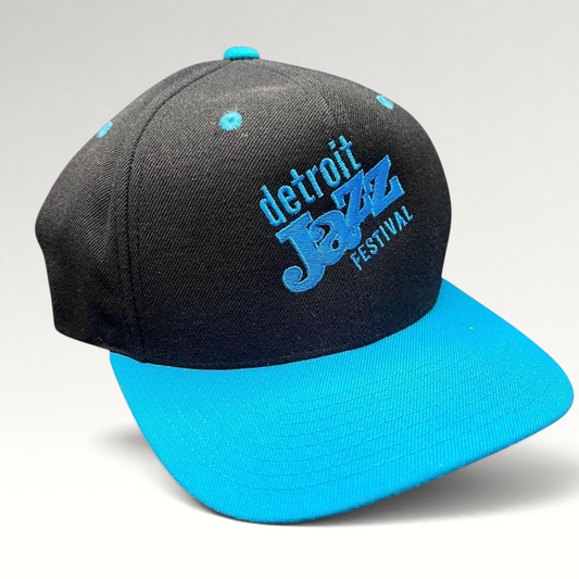 Raree Finds vintage Detroit Jazz Festival snapback hat with a black crown, teal brim, and blue embroidered lettering.
