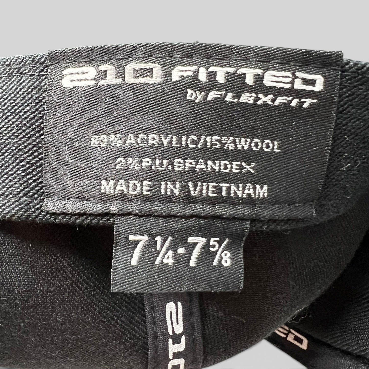 Raree Finds black Flexfit 210 fitted hat interior label showing size 7 1/4 to 7 5/8 and material composition