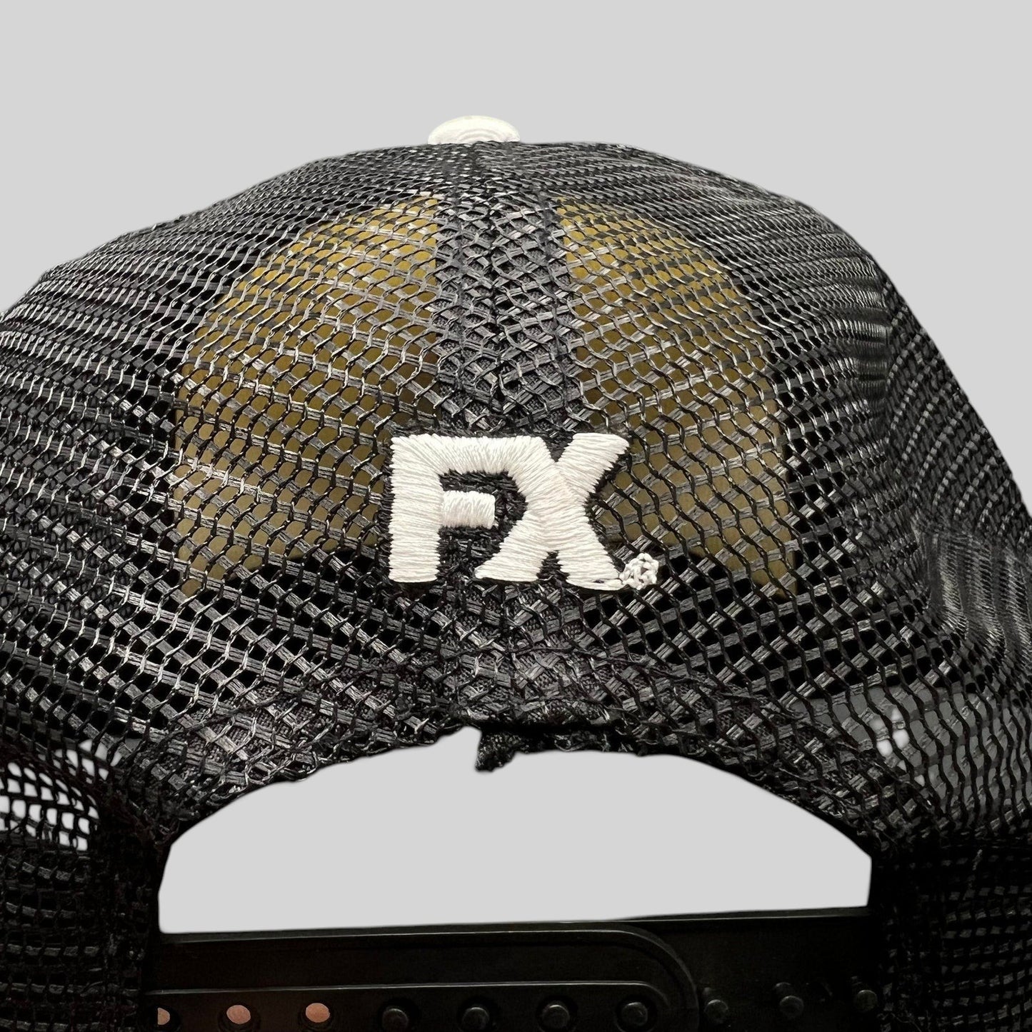 Raree Finds black mesh trucker hat back view with white embroidered FX logo and adjustable snapback closure