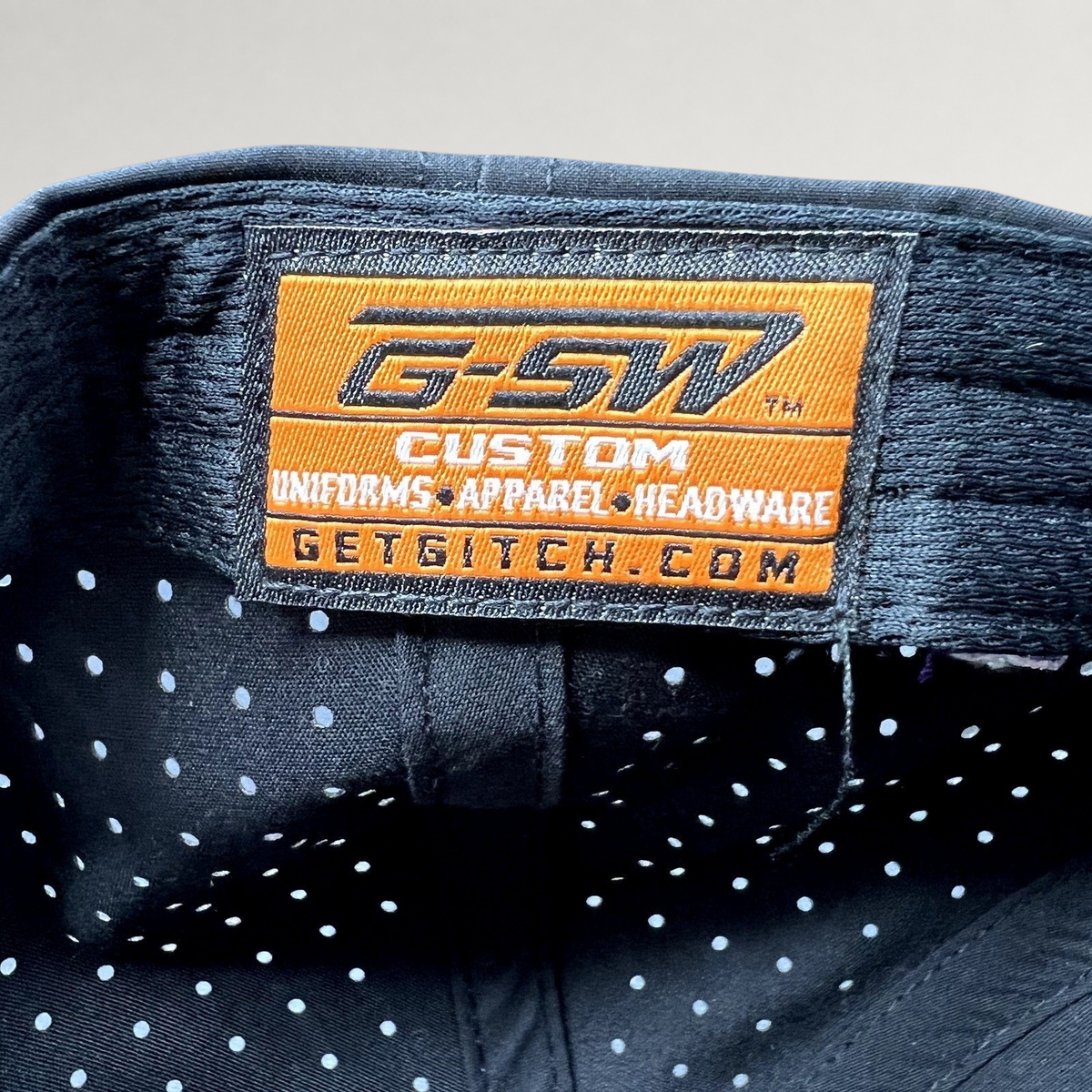 Raree Finds GSW Custom Apparel interior label inside a black perforated snapback hat from The Late Game production