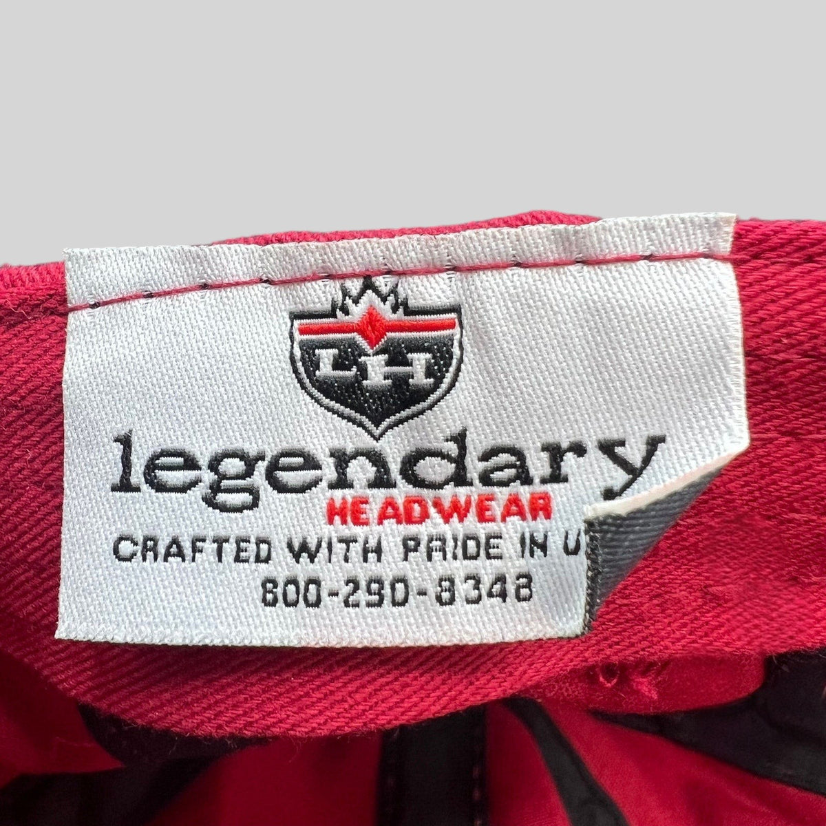 Raree Finds red cotton cap interior tag featuring the Legendary Headwear logo and Made in USA text