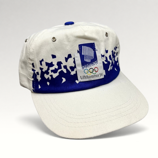 Raree Finds vintage 1994 Lillehammer Winter Olympics flex-back hat with blue and white Nordic graphic and logo patch.