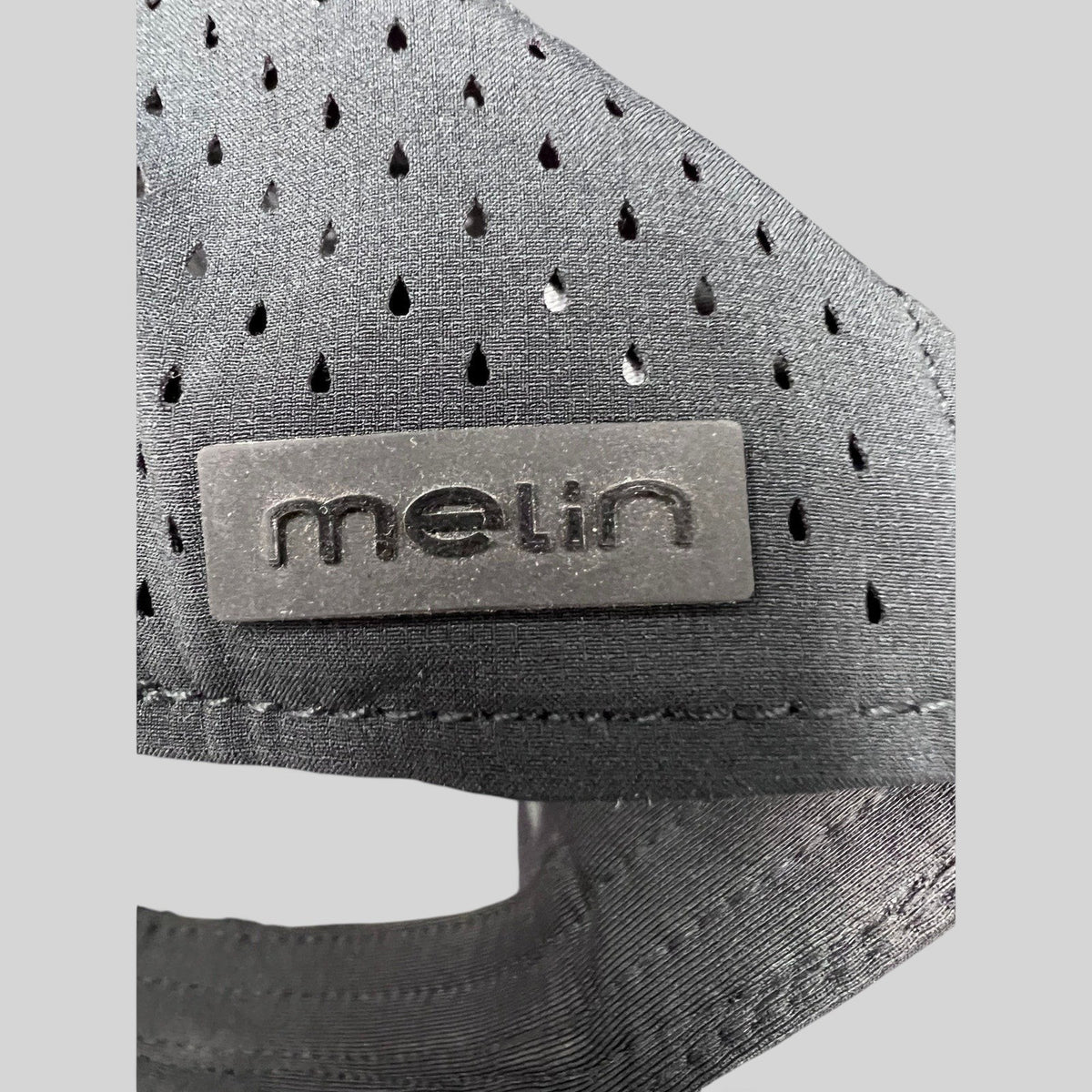 Raree Finds black Melin snapback hat featuring a matte black logo patch and laser-cut ventilation detailing