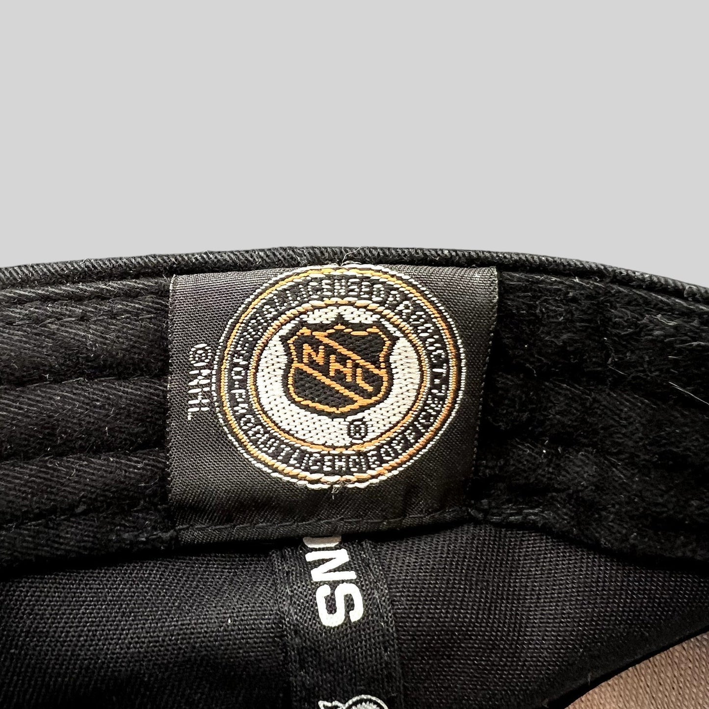 Raree Finds vintage 2002 Detroit Red Wings NHL licensed merchandise tag inside a black New Era strapback hat