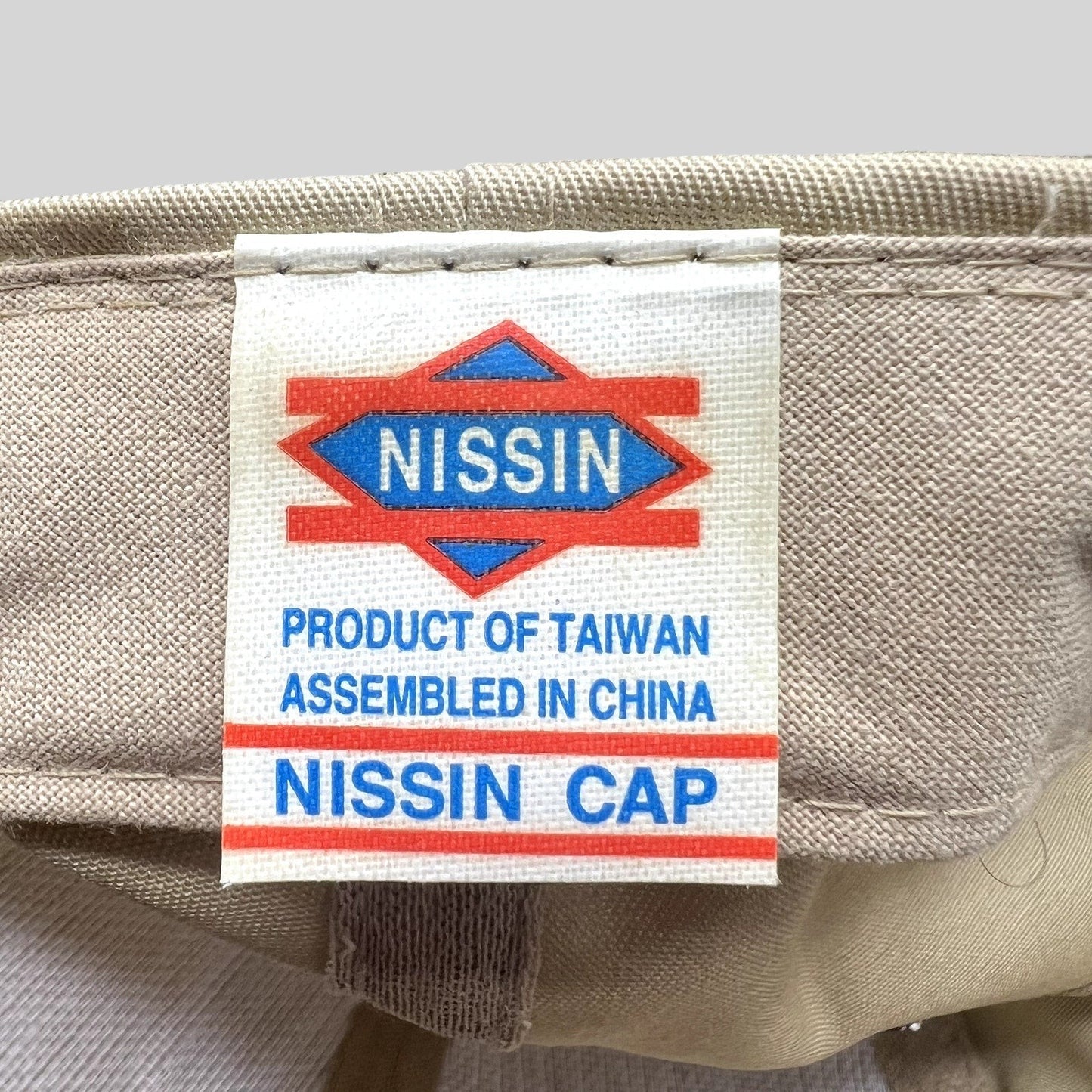 Raree Finds vintage Nissin cap interior label showing product of Taiwan and assembled in China text on khaki fabric