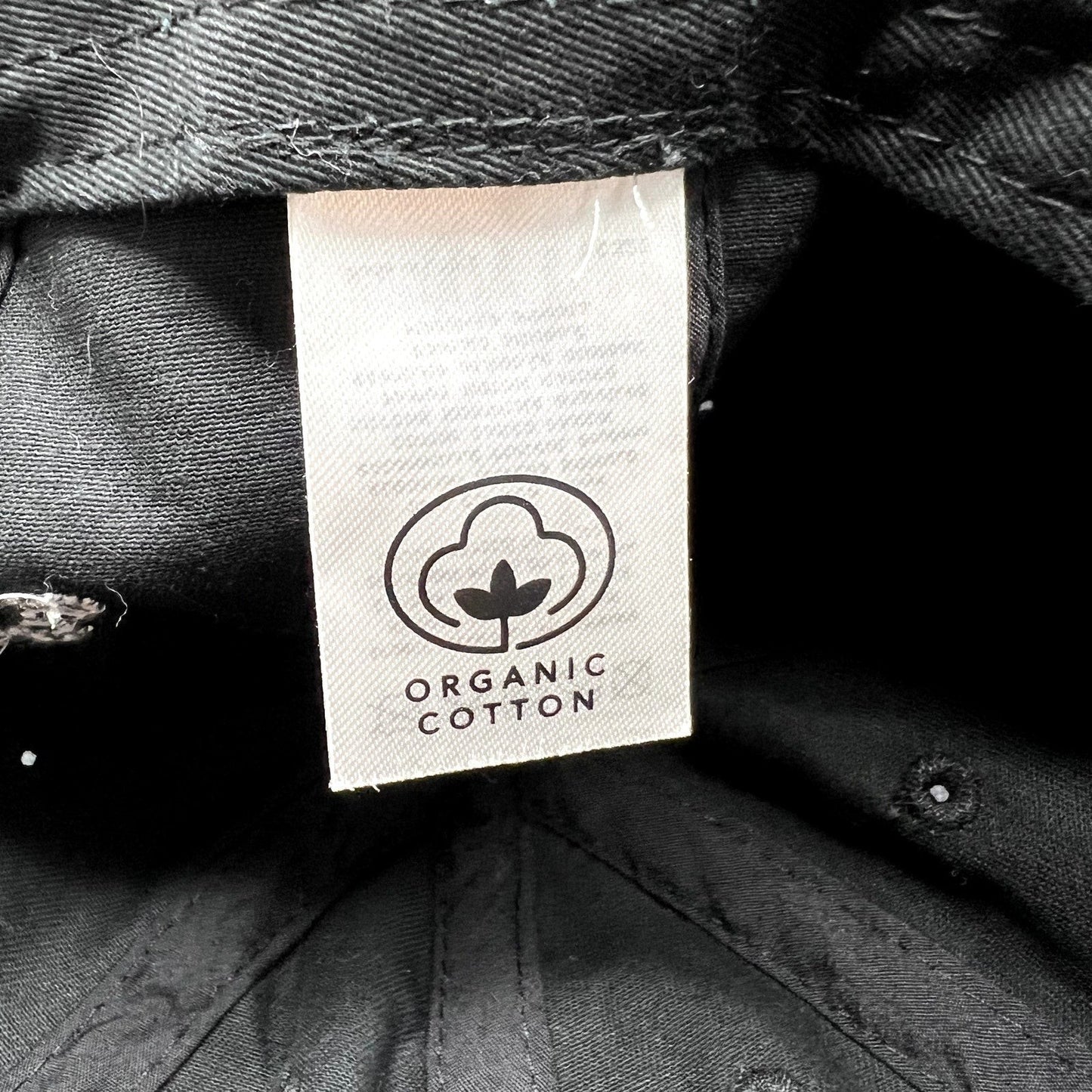 Raree Finds black organic cotton dad cap interior label showing the organic cotton certification logo