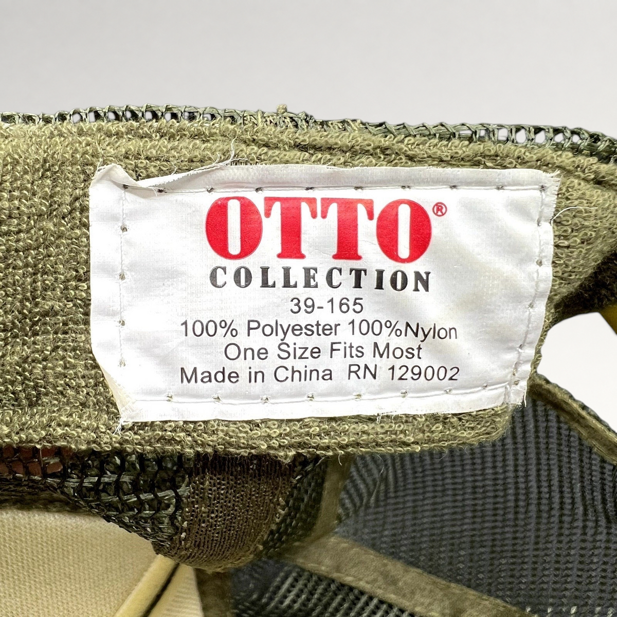 Raree Finds OTTO Collection trucker hat interior tag showing polyester and nylon material details in olive green
