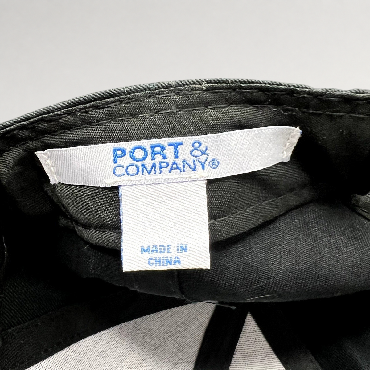 Raree Finds black strapback hat interior showing the Port & Company brand label and Made in China tag