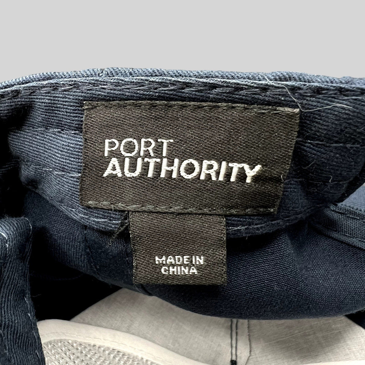 Raree Finds Port Authority navy blue snapback hat interior label showing brand name and Made in China tag