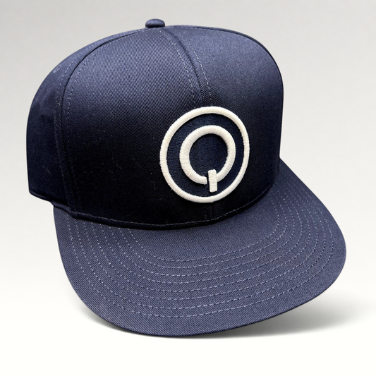 Raree Finds navy blue Quixote Studios snapback hat with a white embroidered circular Q logo and flat brim