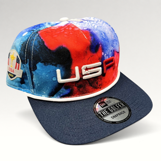 Raree Finds 2023 Ryder Cup Team USA New Era snapback hat with red, white, and blue watercolor print and navy brim.