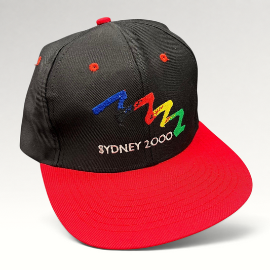 Raree Finds vintage Sydney 2000 Olympics snapback hat with black crown, red brim, and embroidered multicolor logo.