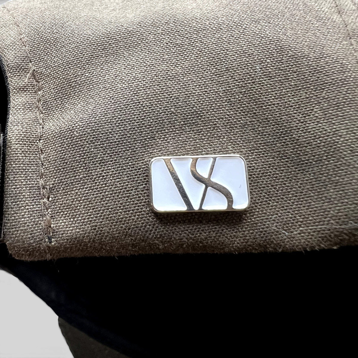 Raree Finds Varsity Headwear olive brown strapback hat featuring a polished metal logo detail on the side panel