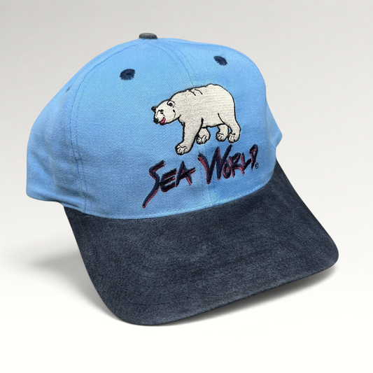 Raree Finds vintage 1990s SeaWorld snapback hat with light blue crown, navy brim, and polar bear embroidery.