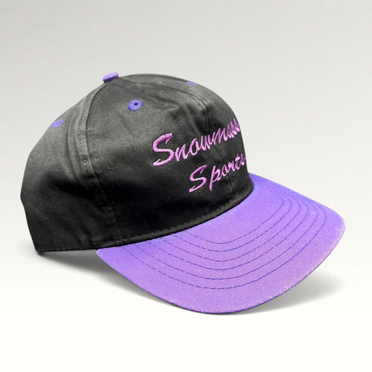Raree Finds vintage 90s Snowmass Sports strapback hat with a black crown, purple brim, and purple script embroidery.