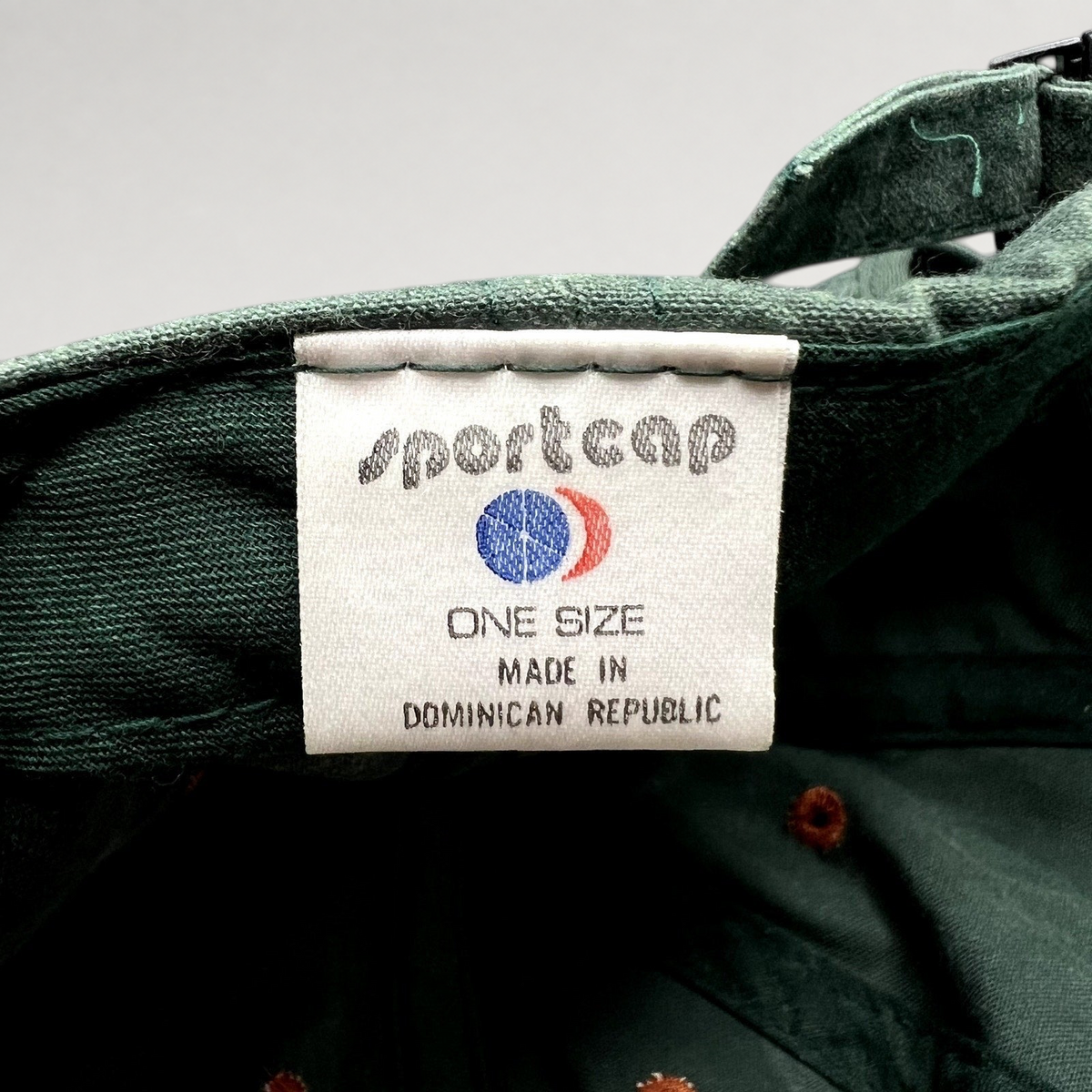 Raree Finds vintage green strapback hat interior label showing Sportcap branding and Dominican Republic origin