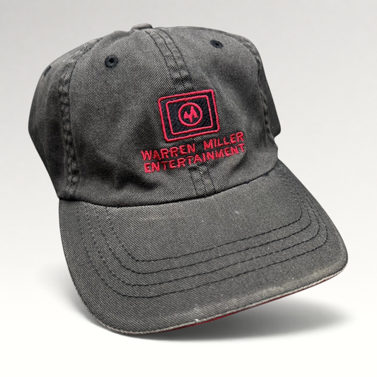 Raree Finds vintage black Flexfit hat with red Warren Miller Entertainment logo embroidery and contrast brim piping.