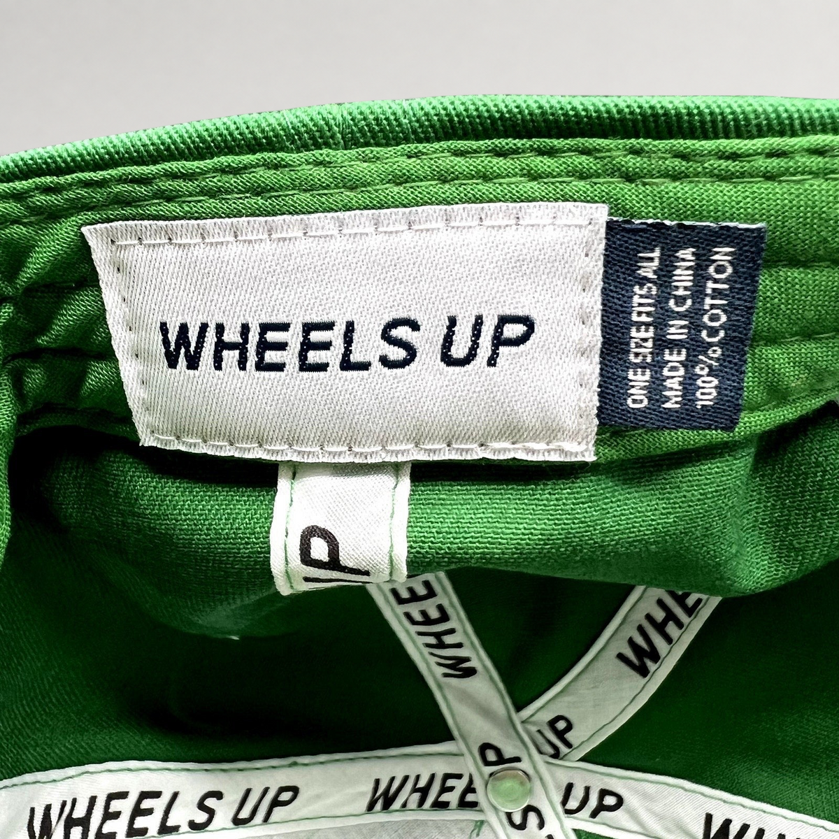 Raree Finds green cotton Wheels Up cap interior label with branded taping and size information