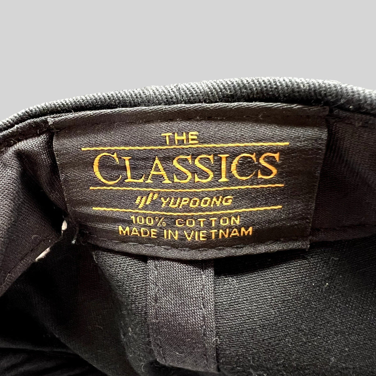 Raree Finds Yupoong Classics black cotton snapback hat interior label with gold embroidery