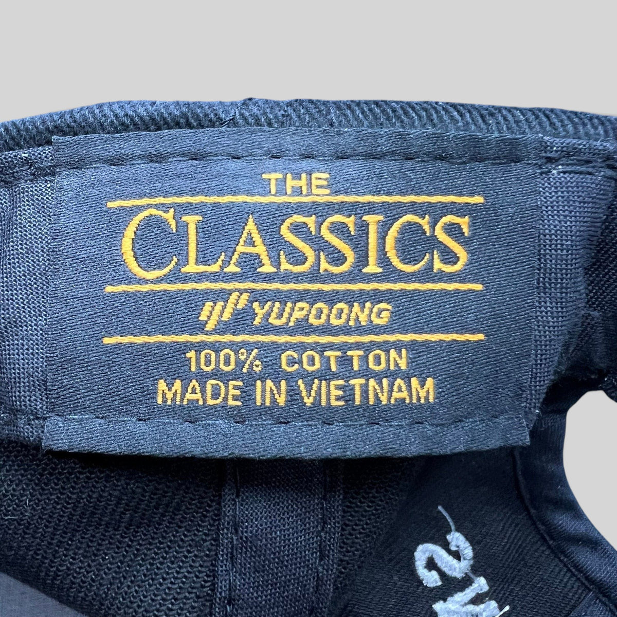 Raree Finds black Yupoong The Classics 100 percent cotton hat interior label with gold embroidery