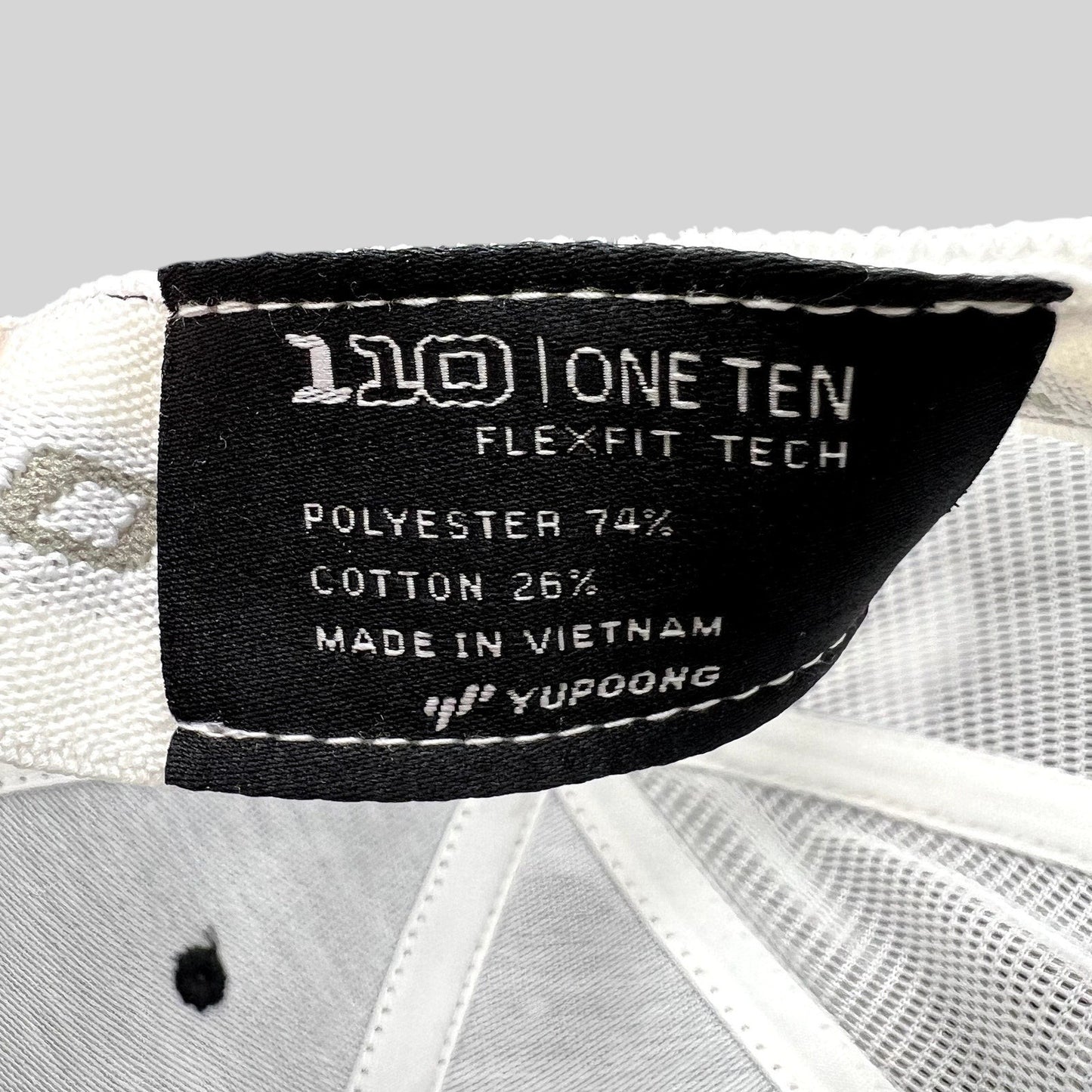 Raree Finds Yupoong Flexfit 110 trucker hat interior label showing polyester and cotton material composition