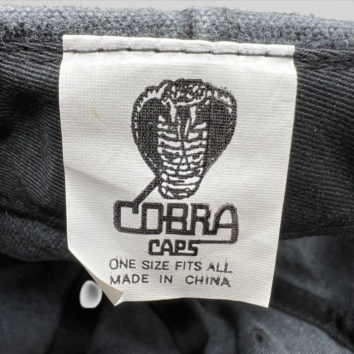 Raree Finds vintage 1998 Cobra Caps hat interior label showing brand logo and manufacturing details