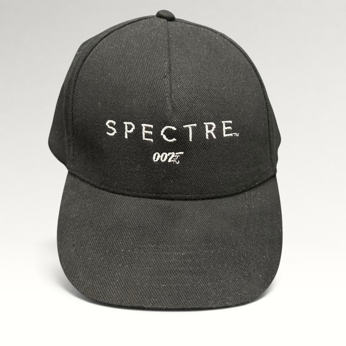 Raree Finds black cotton strapback hat featuring white embroidered SPECTRE text and 007 logo from the 2015 film.