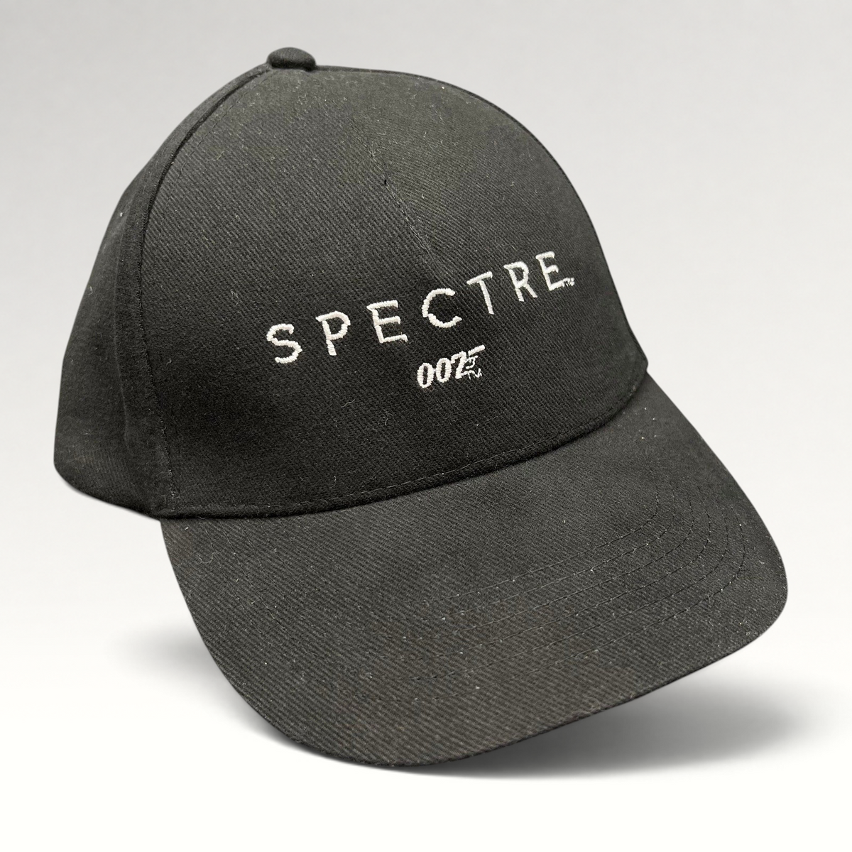 Raree Finds black cotton strapback hat featuring white embroidered SPECTRE text and 007 logo from the 2015 film.