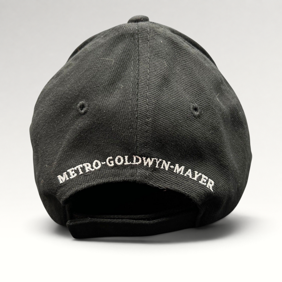 Raree Finds black cotton strapback hat featuring white Metro-Goldwyn-Mayer embroidery on the rear panel