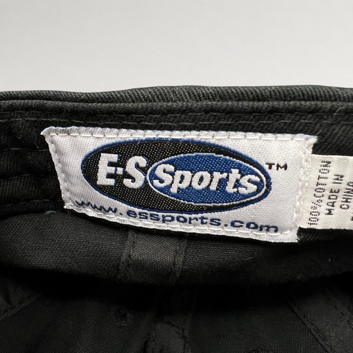 Raree Finds black cotton hat interior label featuring the E-S Sports logo and website text