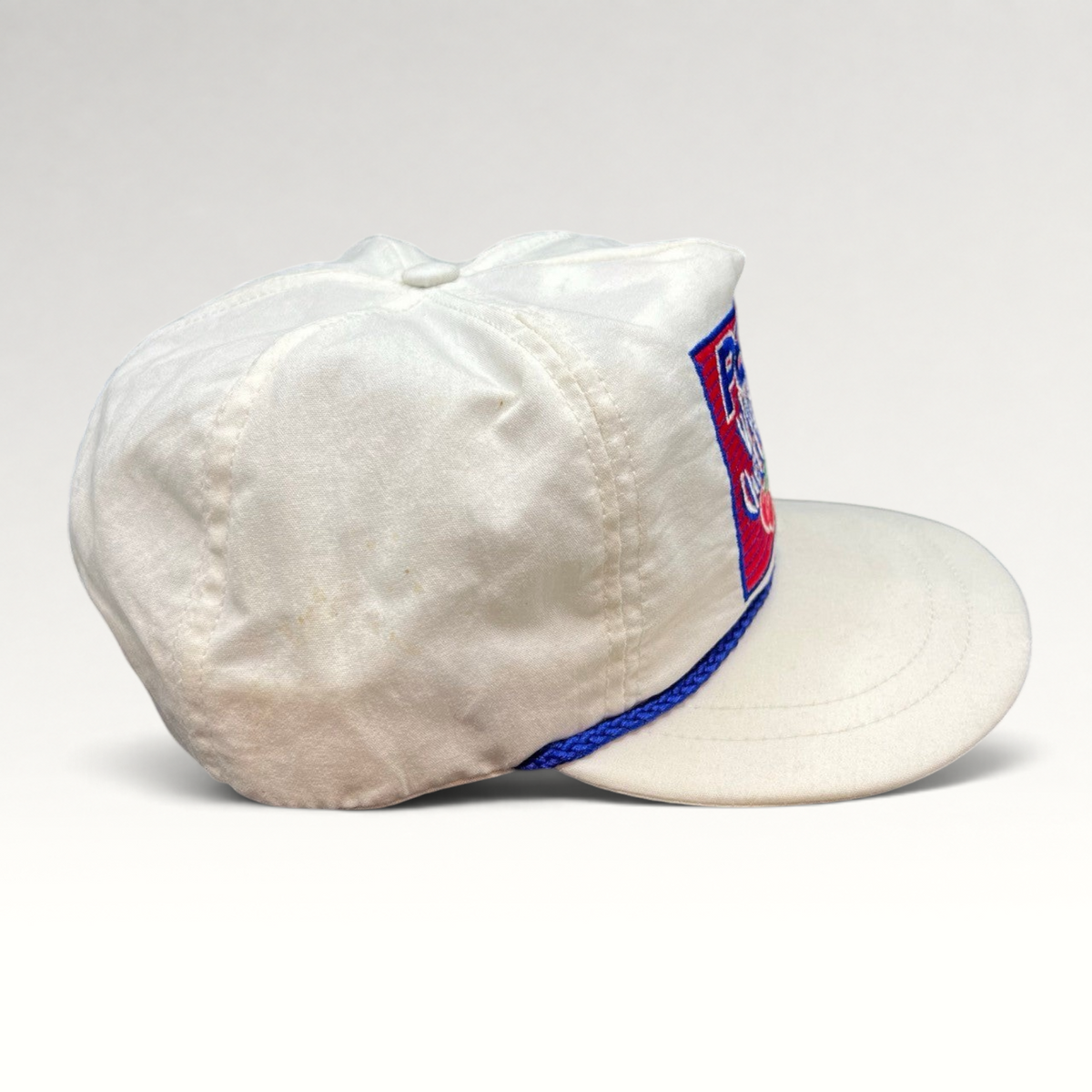 Vintage Hat Source vintage white Pepsi Wild Cherry snapback hat with blue rope trim and embroidered logo, side view.