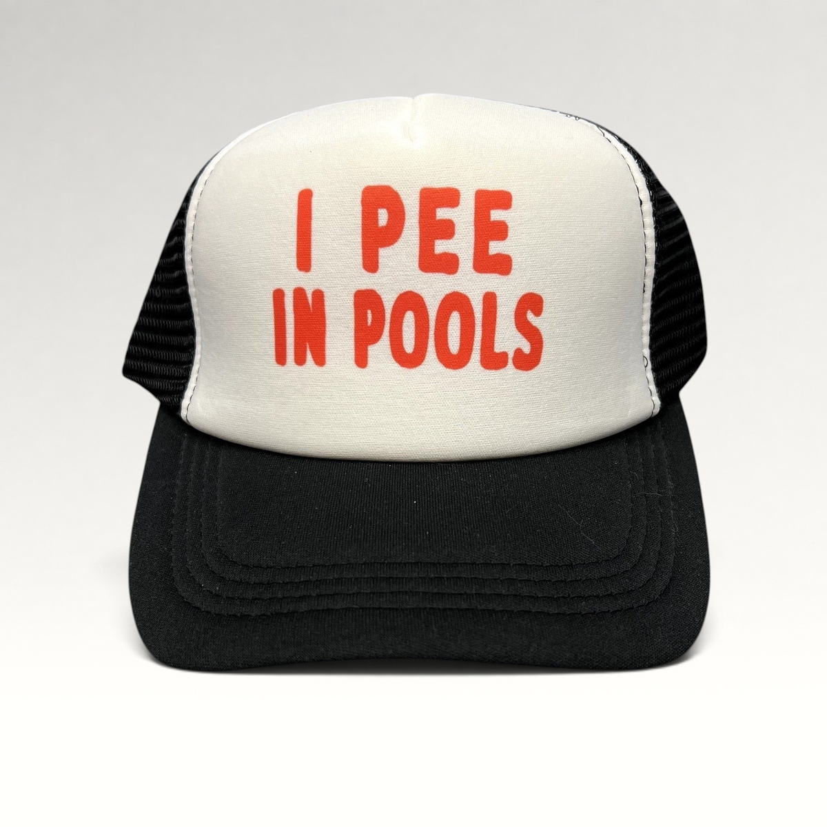 Raree Finds novelty trucker hat with white foam front, black mesh back, and red I PEE IN POOLS text on the front.