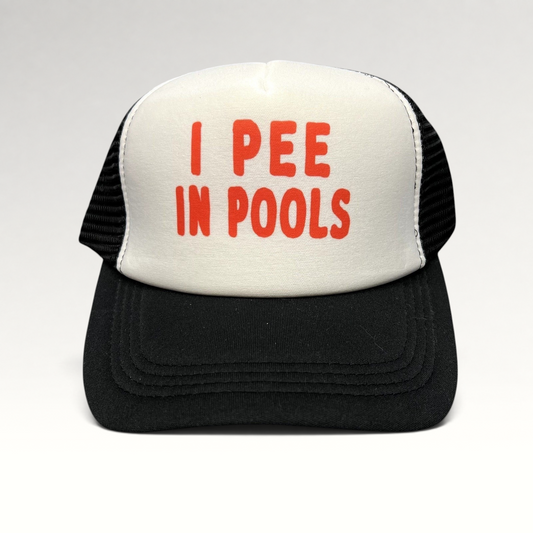 Raree Finds novelty trucker hat with white foam front, black mesh back, and red I PEE IN POOLS text on the front.