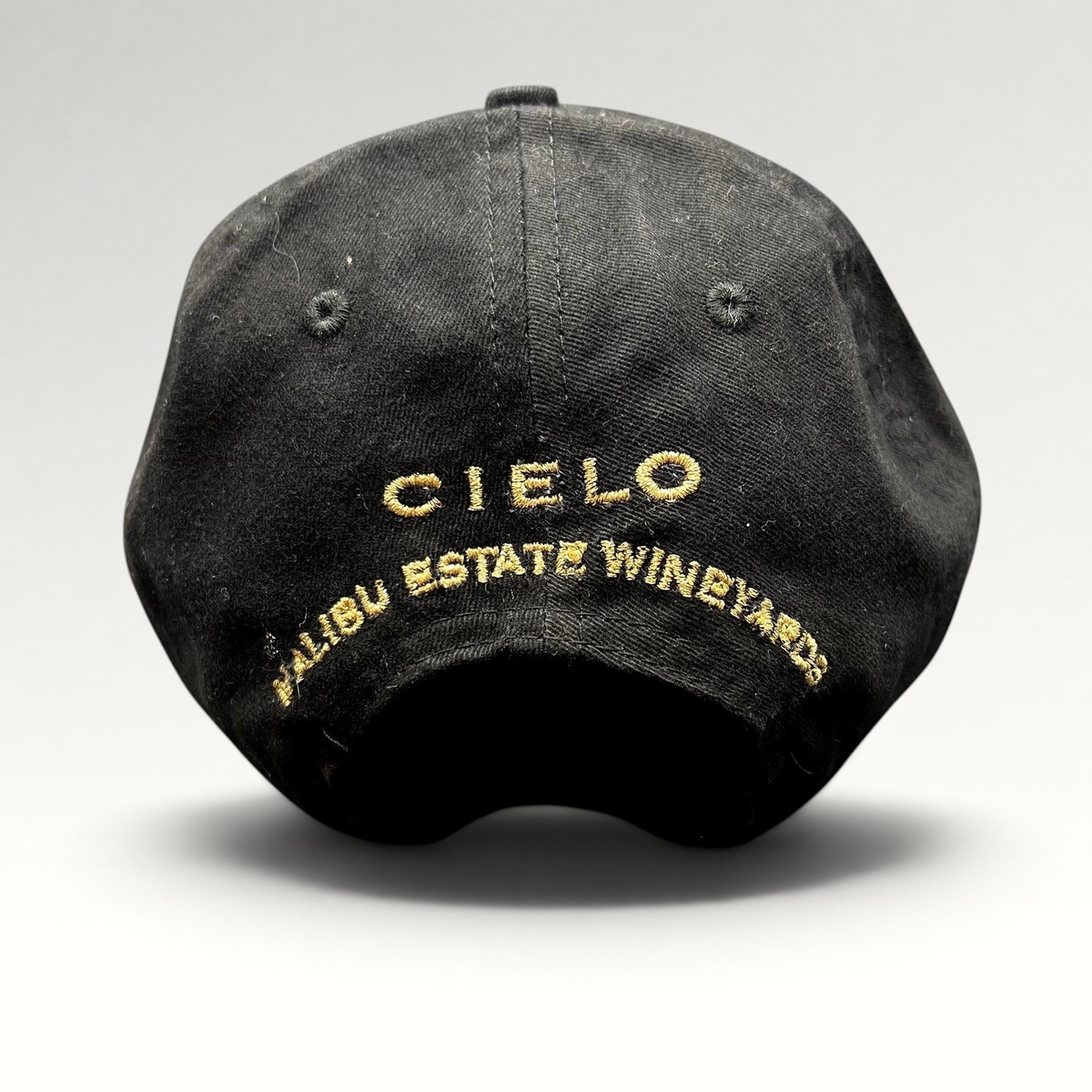 Raree Finds black cotton strapback hat featuring gold embroidered Cielo Malibu Estate Vineyards text on the back