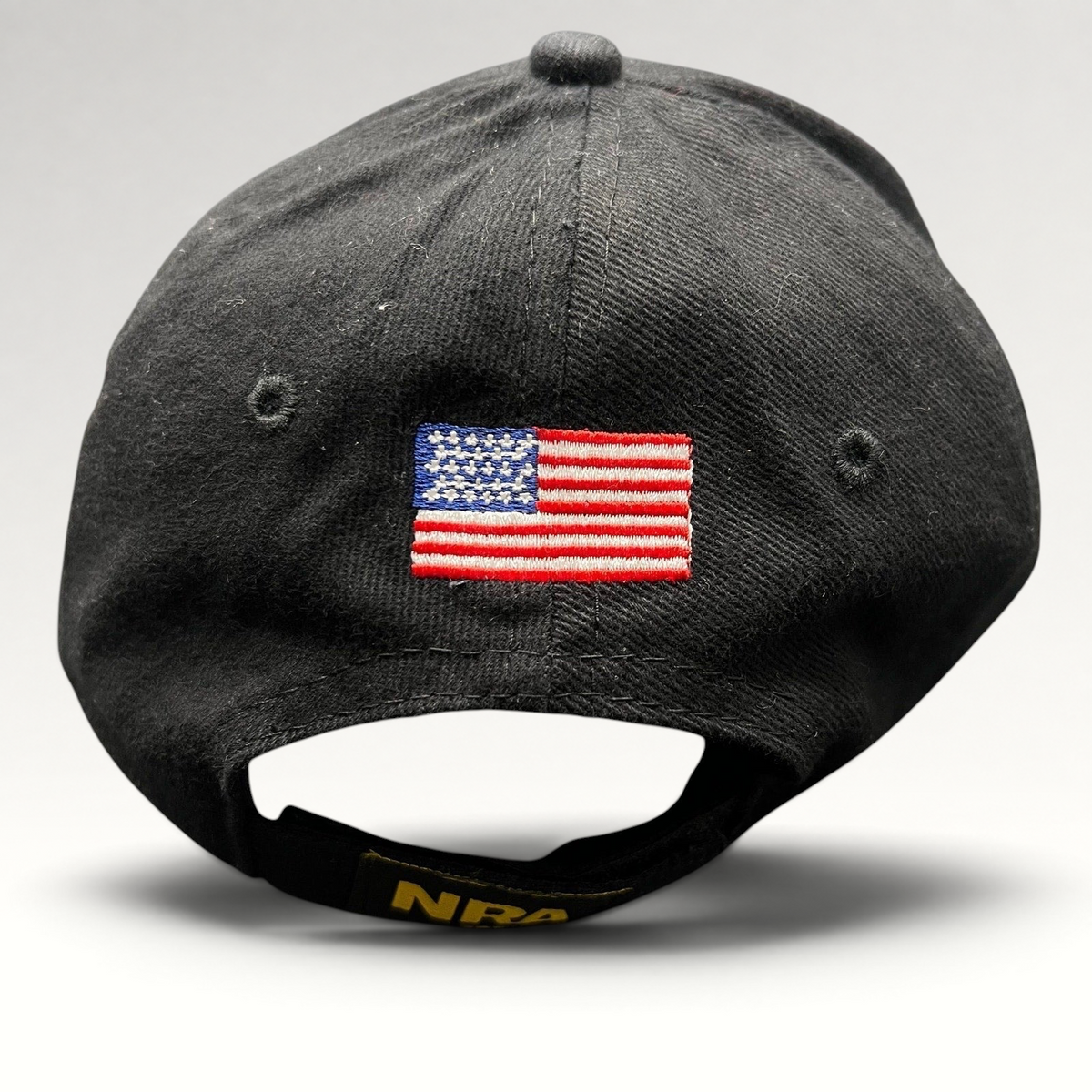 Raree Finds black strapback hat featuring an embroidered American flag on the back and NRA logo on the adjustable strap