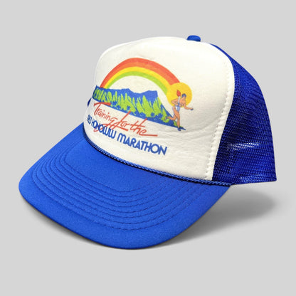 Raree Finds vintage 1983 Honolulu Marathon trucker hat with white foam front, rainbow graphic, and blue mesh back.