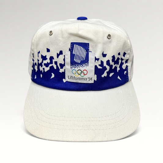 Raree Finds vintage 1994 Lillehammer Winter Olympics hat with white crown, blue brim, and Olympic emblem patch.
