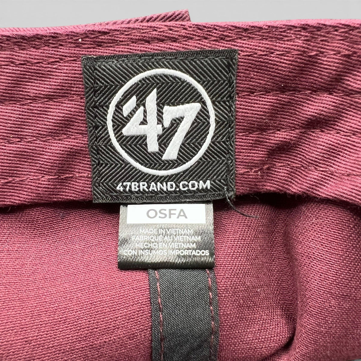 Raree Finds 47 Brand interior label on a burgundy promotional strapback hat with OSFA sizing tag