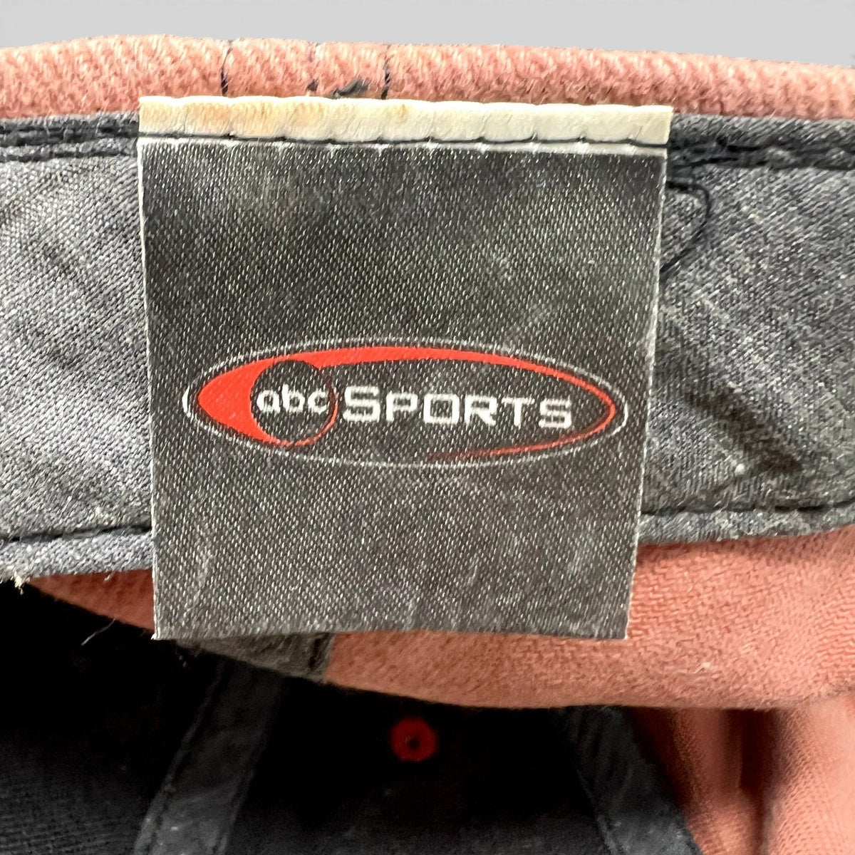 Raree Finds vintage ABC Sports hat interior tag with embroidered logo on a black fabric label inside the cap