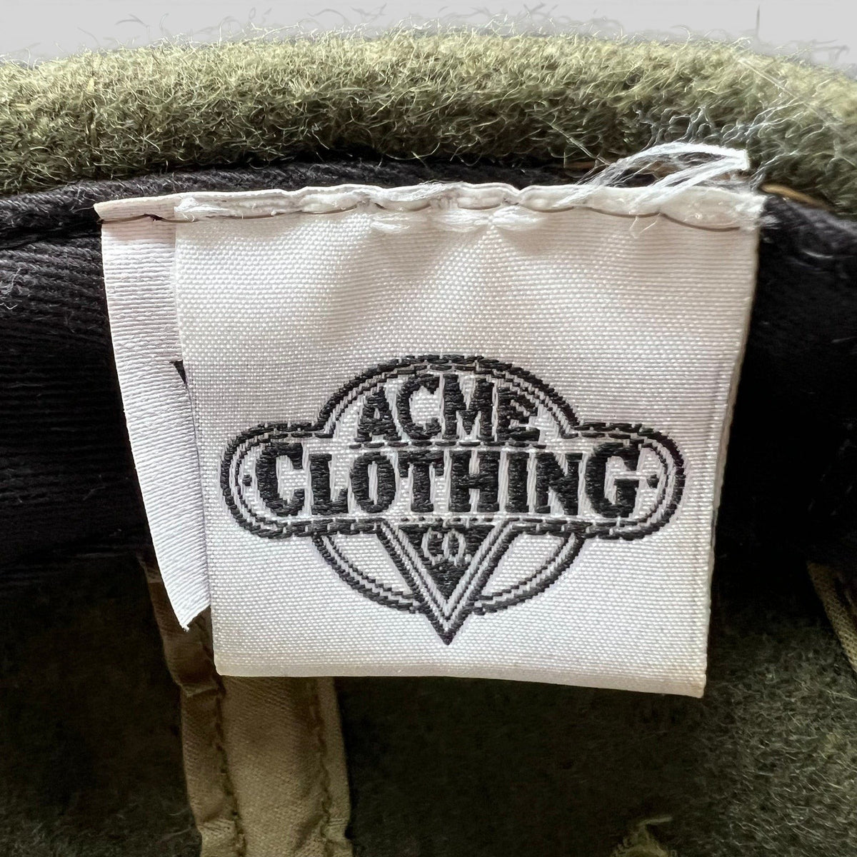 Raree Finds vintage 1991 Acme Clothing Co. interior brand tag inside an olive wool Harley-Davidson Taz hat